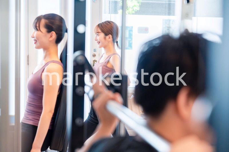 ジムのマシーンでトレーニングをする人