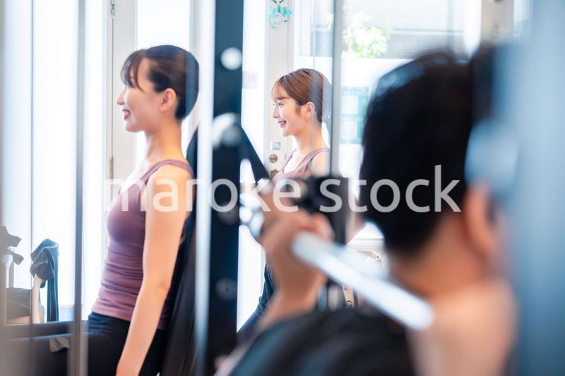 ジムのマシーンでトレーニングをする人