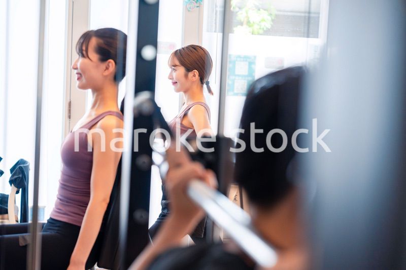 ジムのマシーンでトレーニングをする人