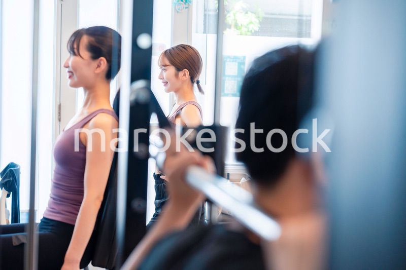 ジムのマシーンでトレーニングをする人