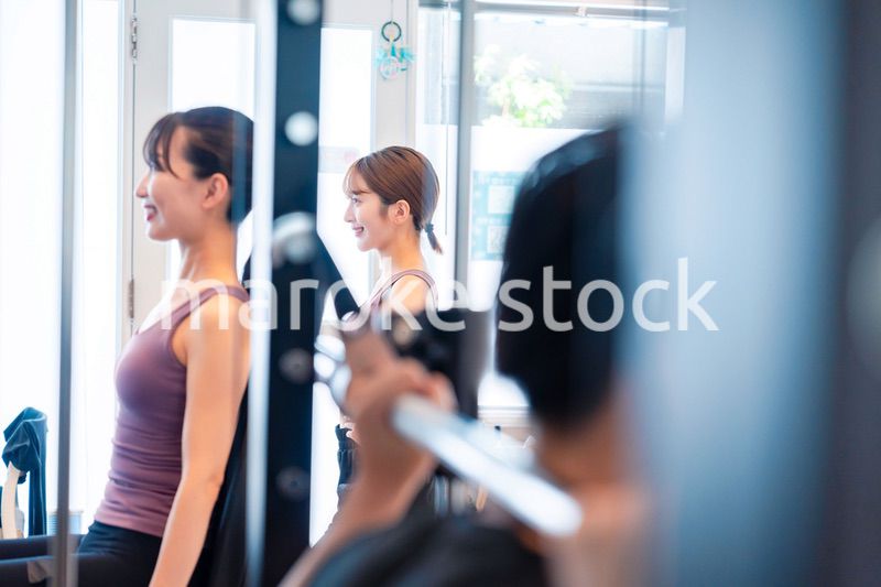 ジムのマシーンでトレーニングをする人