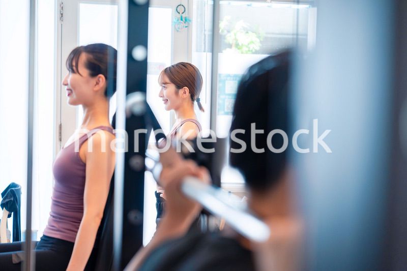 ジムのマシーンでトレーニングをする人