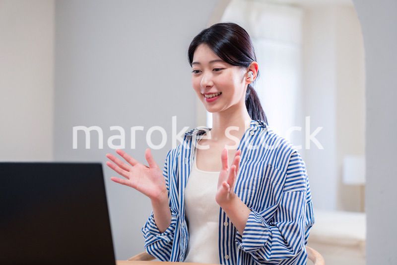 在宅でリモート会議に参加する若い女性社員