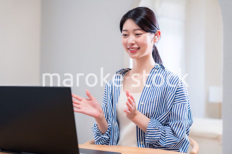 在宅でリモート会議に参加する若い女性社員