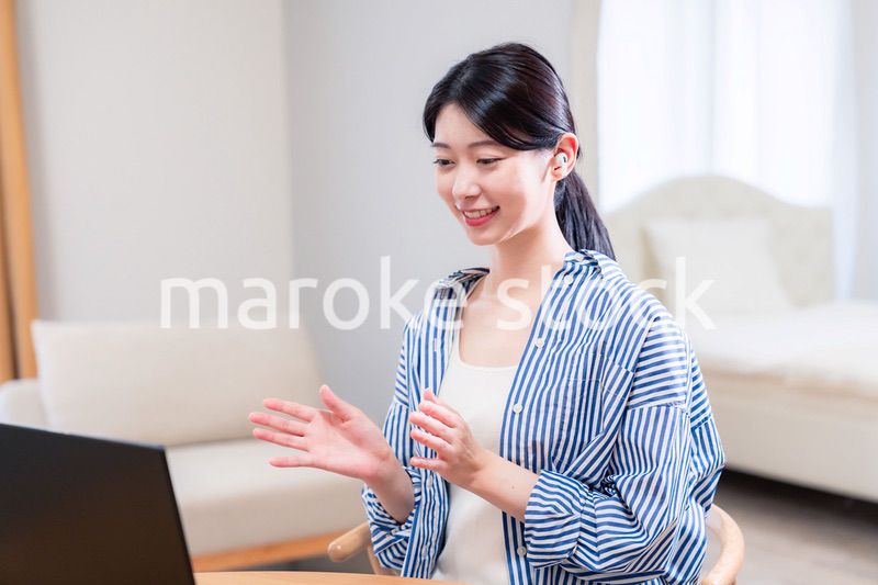 在宅でリモート会議に参加する若い女性社員