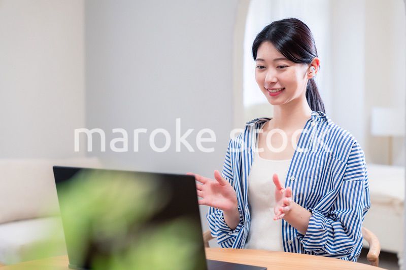 在宅でリモート会議に参加する若い女性社員