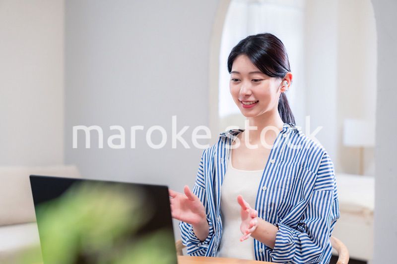 在宅でリモート会議に参加する若い女性社員