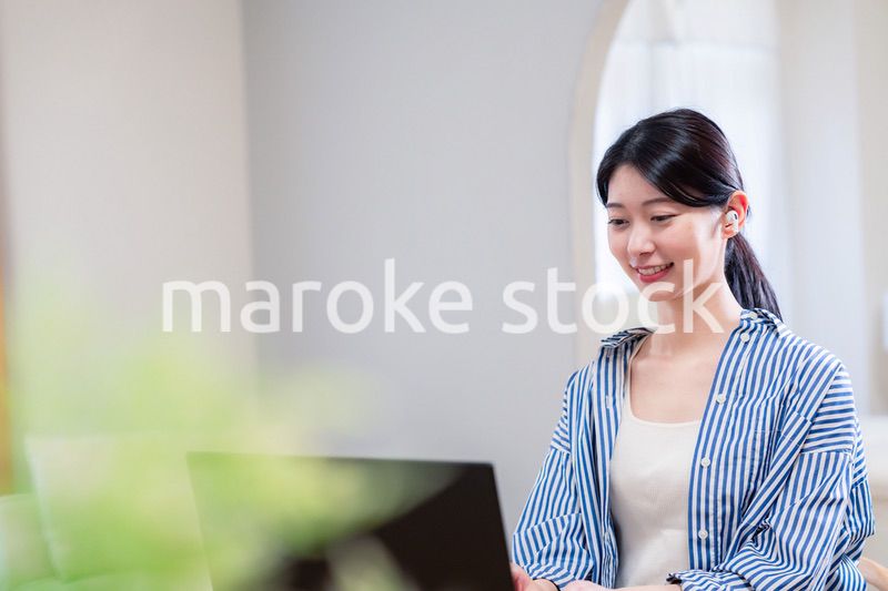 在宅でリモート会議に参加する若い女性社員