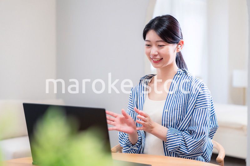 在宅でリモート会議に参加する若い女性社員