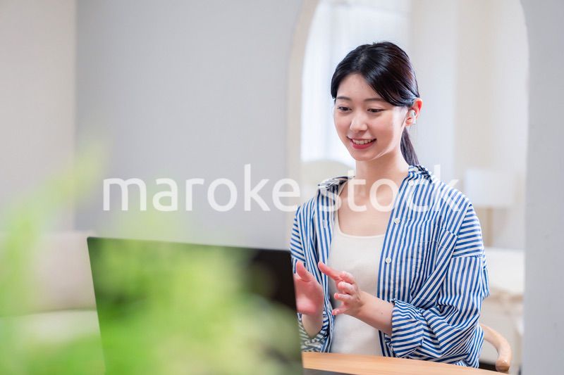 在宅でリモート会議に参加する若い女性社員