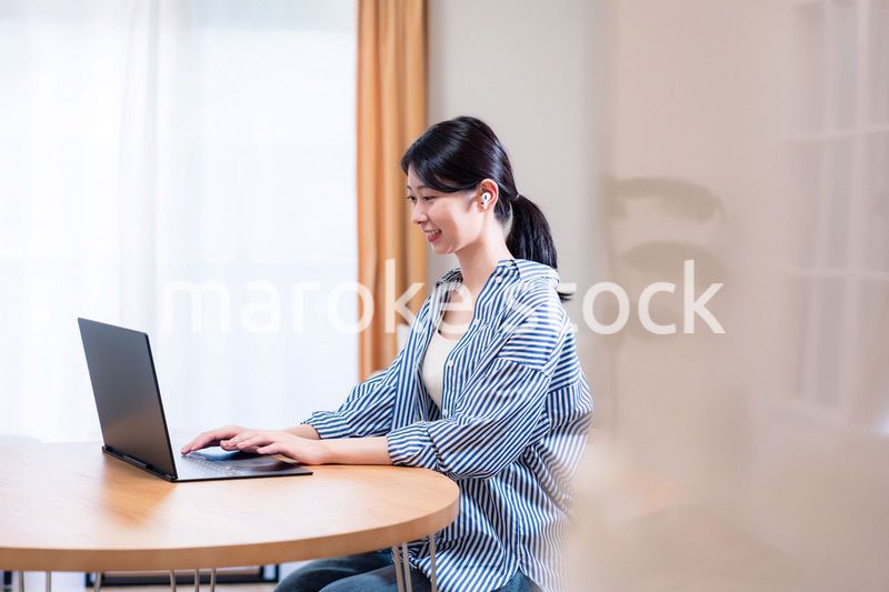 在宅でリモート会議に参加する若い女性社員