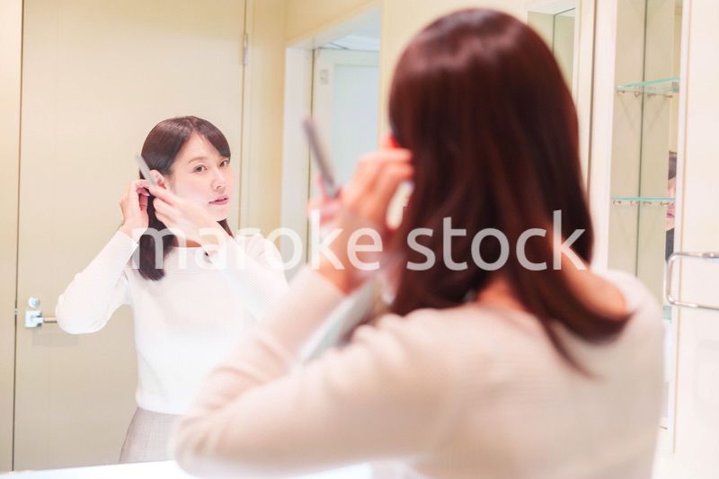 お出かけ前に身だしなみを整えるミドルシニアの女性