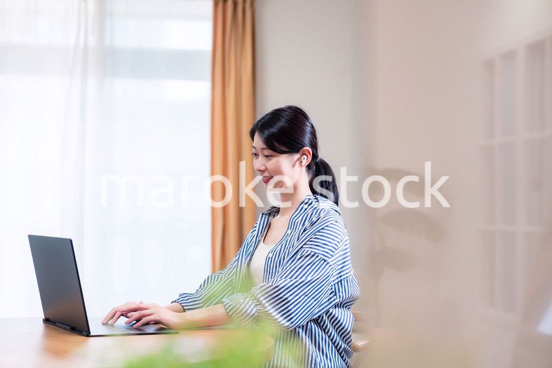 在宅でリモート会議に参加する若い女性社員