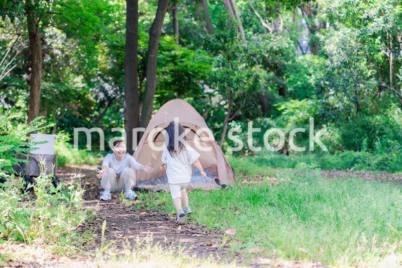 森の中でかけっこをする子どもとお母さん
