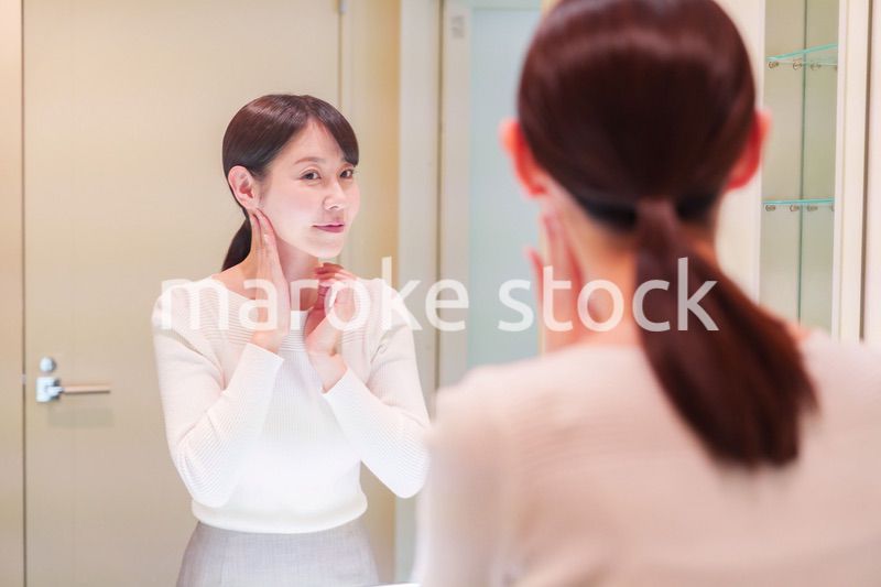 お出かけ前に身だしなみを整えるミドルシニアの女性