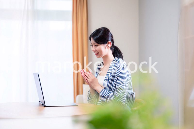 在宅でリモート会議に参加する若い女性社員