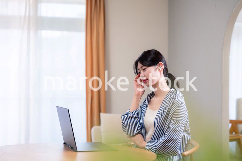 在宅勤務をしながら頭を抱える若い女性