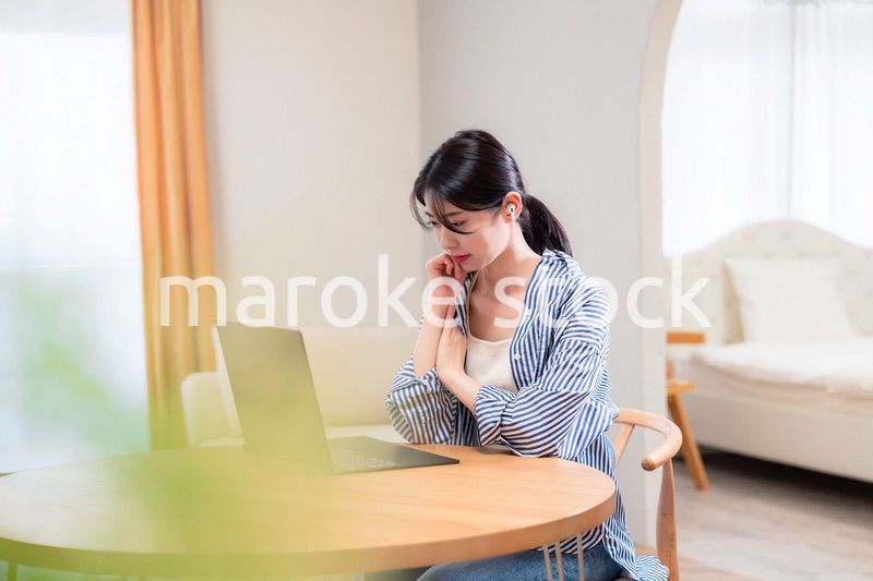 在宅勤務をしながら頭を抱える若い女性