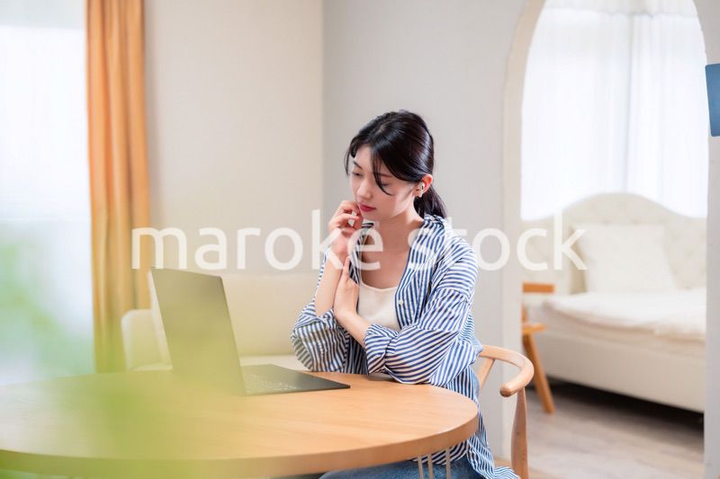 在宅勤務をしながら頭を抱える若い女性