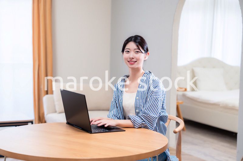 自宅で笑顔でリモート会議に参加する若い女性