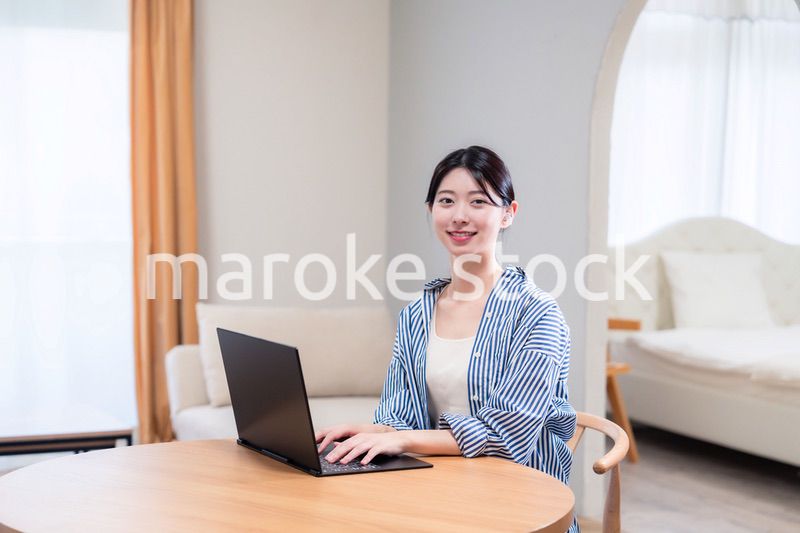 自宅で笑顔でリモート会議に参加する若い女性