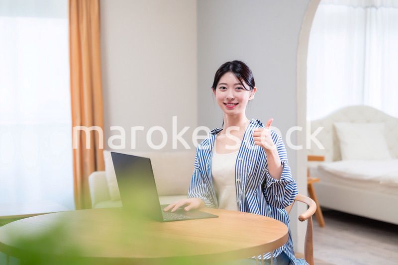 自宅で笑顔でリモート会議に参加する若い女性