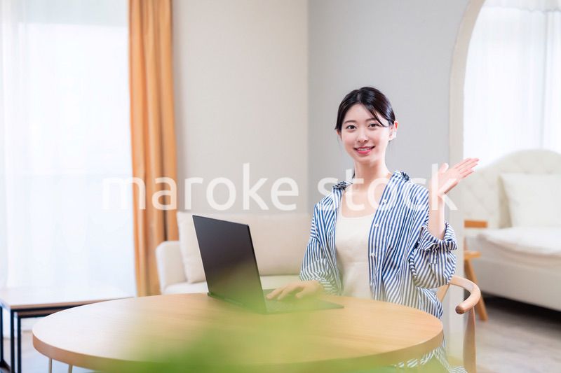 自宅で笑顔でリモート会議に参加する若い女性