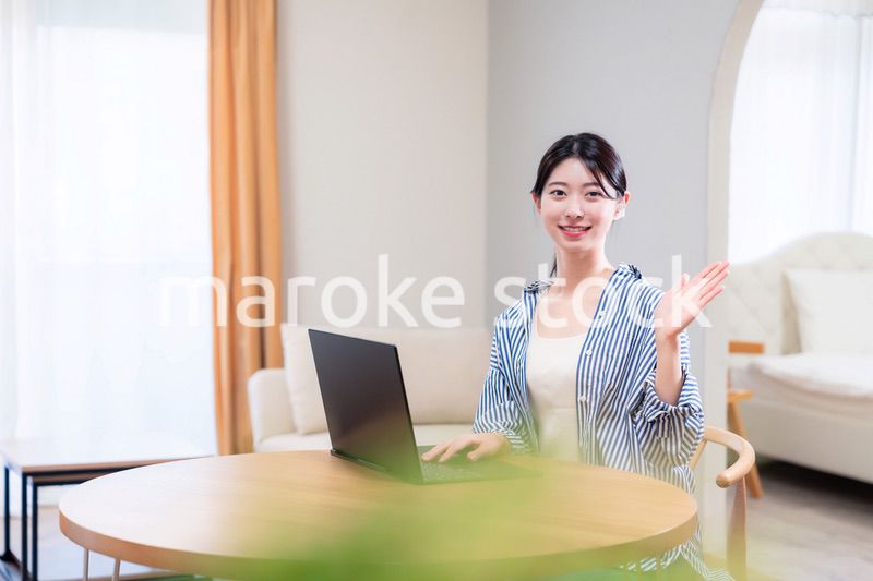 自宅で笑顔でリモート会議に参加する若い女性