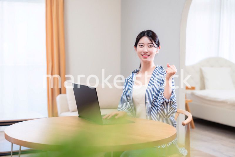 自宅で笑顔でリモート会議に参加する若い女性