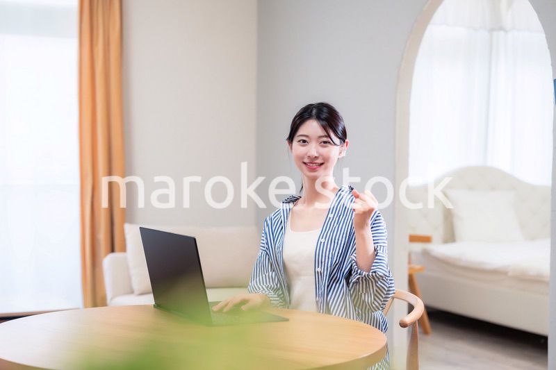 自宅で笑顔でリモート会議に参加する若い女性