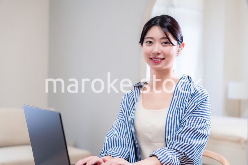 自宅で笑顔でリモート会議に参加する若い女性