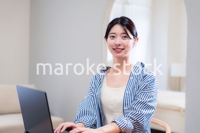 自宅で笑顔でリモート会議に参加する若い女性