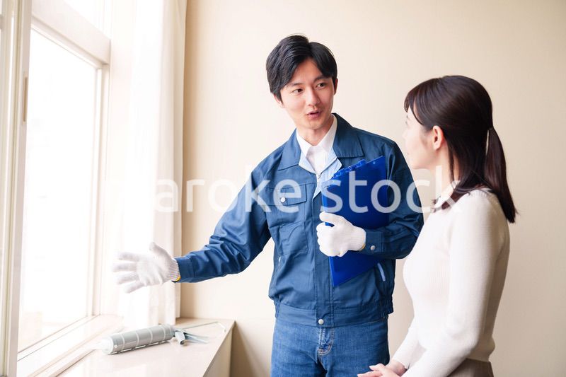 修理業者に家の修理をお願いする女性