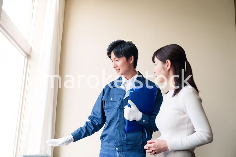 修理業者に家の修理をお願いする女性