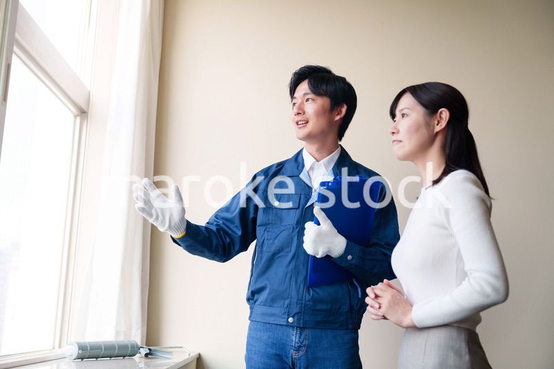 修理業者に家の修理をお願いする女性