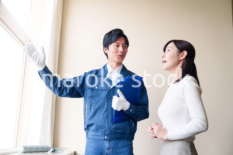 修理業者に家の修理をお願いする女性