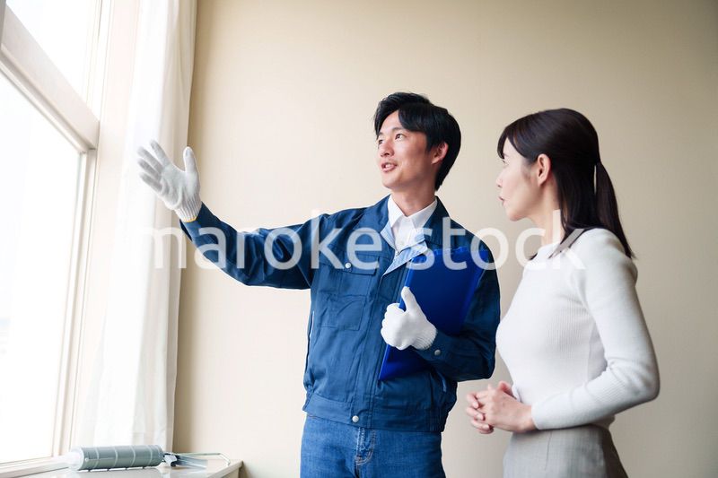 修理業者に家の修理をお願いする女性