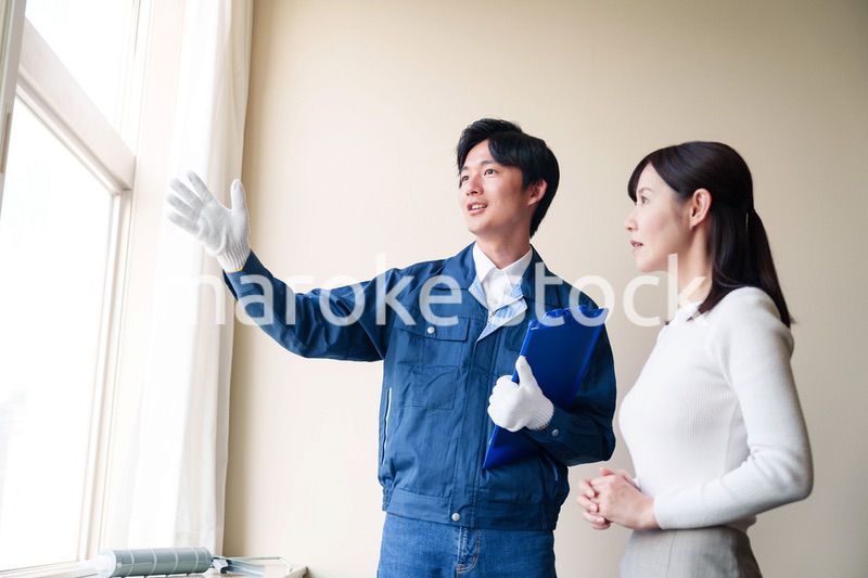 修理業者に家の修理をお願いする女性