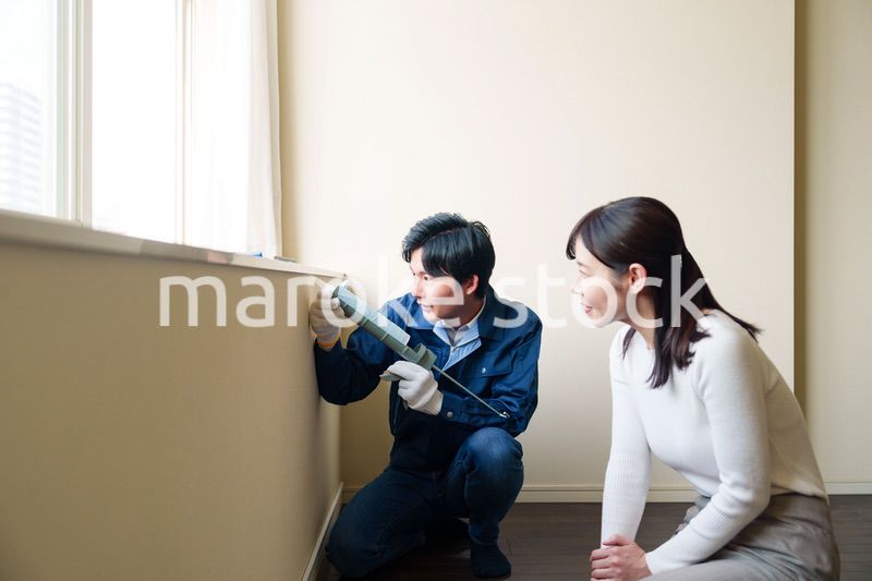 修理業者に家の修理をお願いする女性