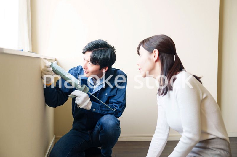 修理業者に家の修理をお願いする女性