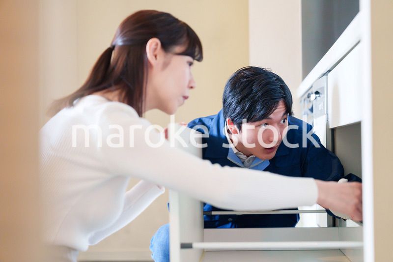 修理業者に家の修理をお願いする女性