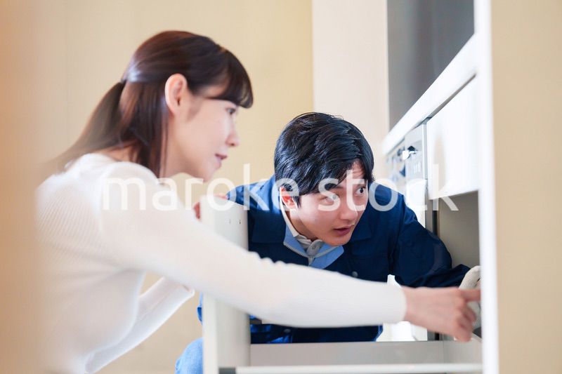 修理業者に家の修理をお願いする女性