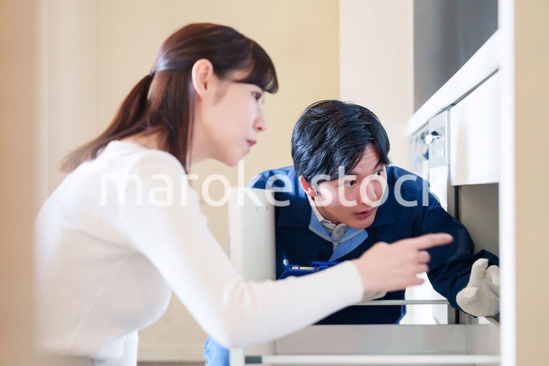 修理業者に家の修理をお願いする女性
