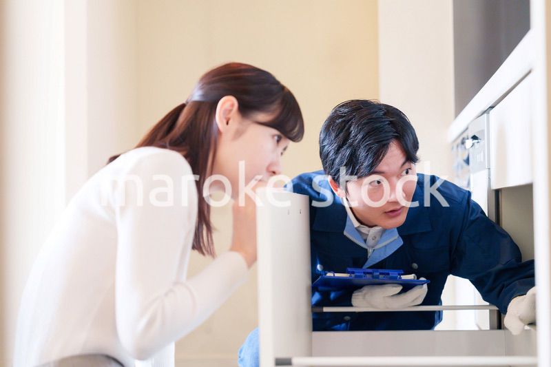 修理業者に家の修理をお願いする女性