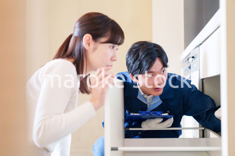 修理業者に家の修理をお願いする女性