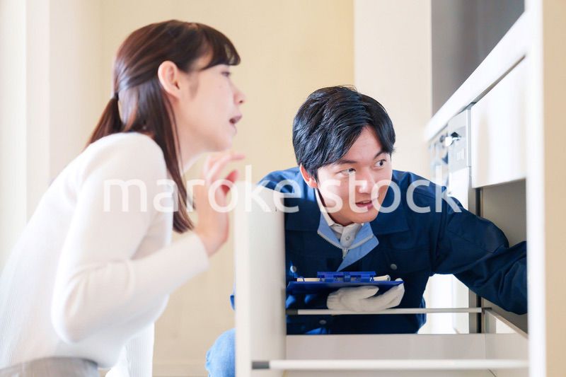 修理業者に家の修理をお願いする女性