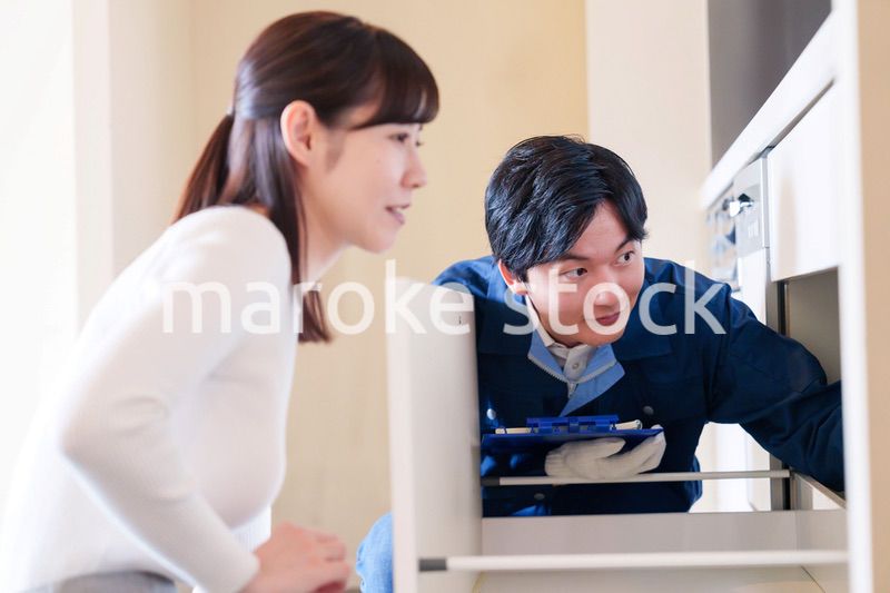 修理業者に家の修理をお願いする女性