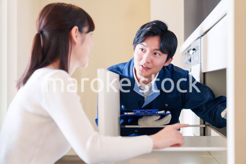 修理業者に家の修理をお願いする女性