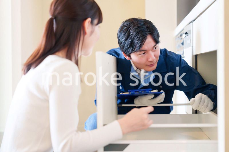 修理業者に家の修理をお願いする女性