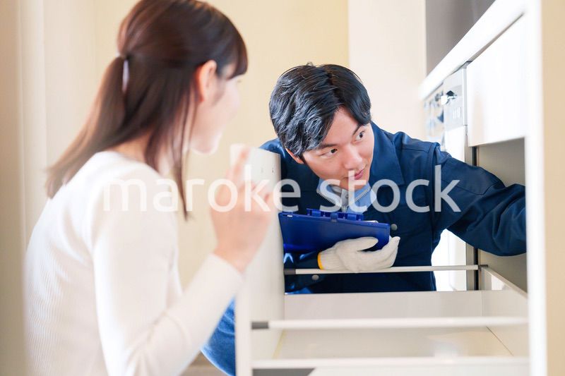 修理業者に家の修理をお願いする女性